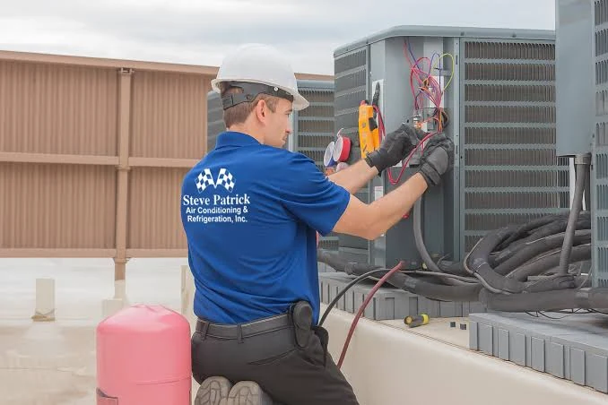 Technician checking an outdoor cooling system with diagnostic gauges